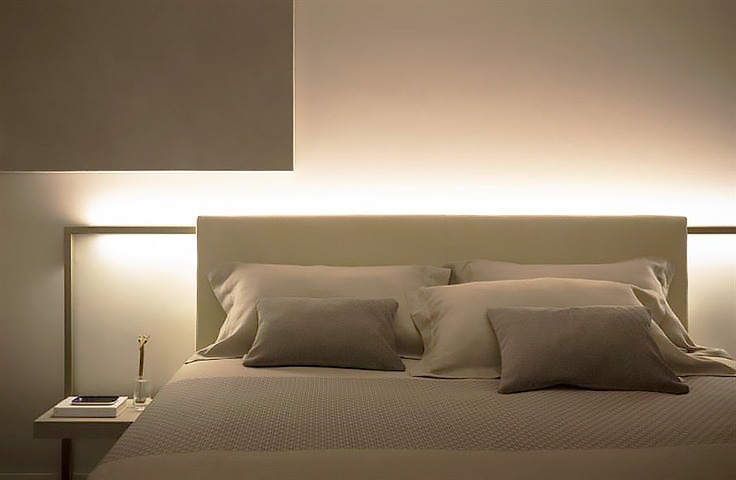 Belysning bakom säng i sovrum